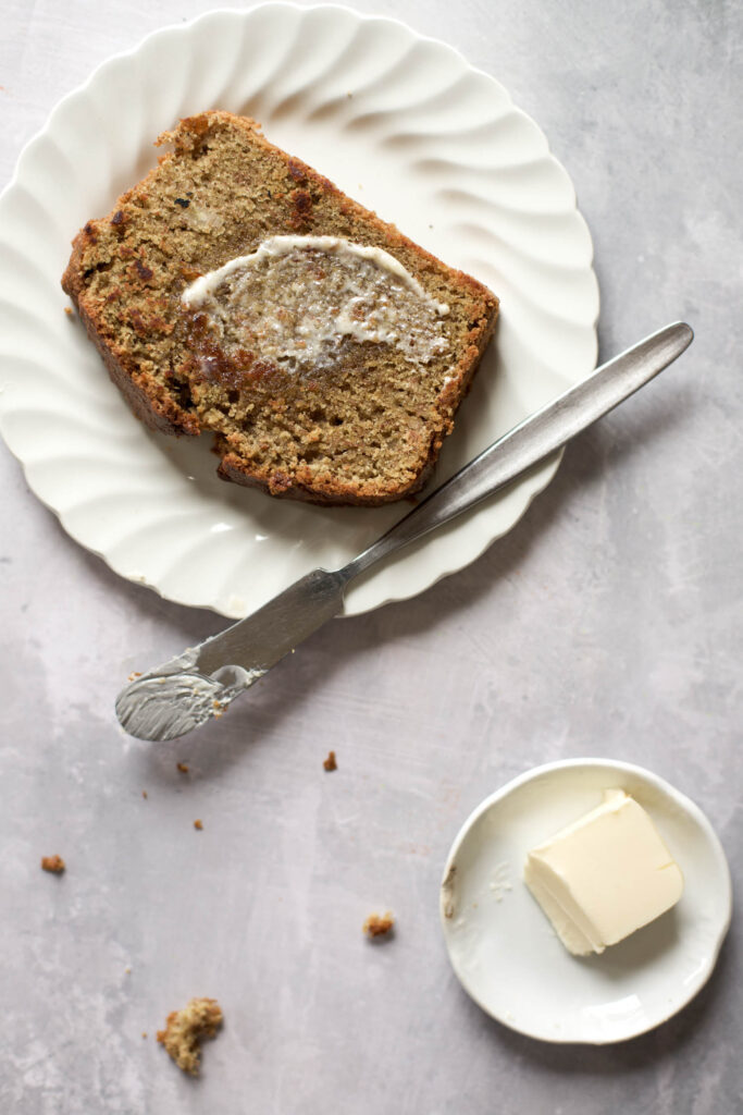 Buckwheat flour banana bread on a plate with melted butter